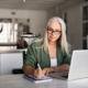 woman writing changes to make after selling her business